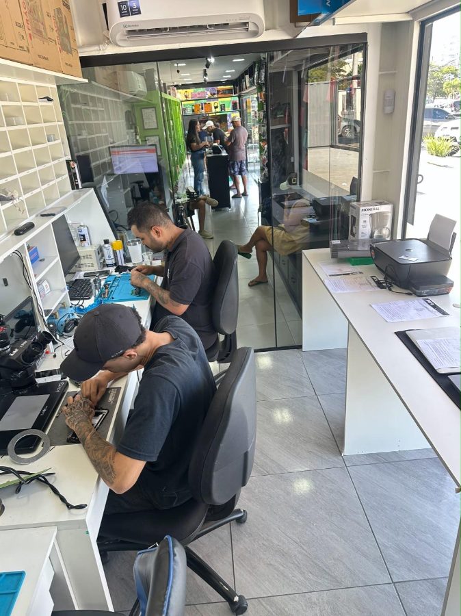 Equipe da Pera Acessórios trabalhando em celulares na bancada