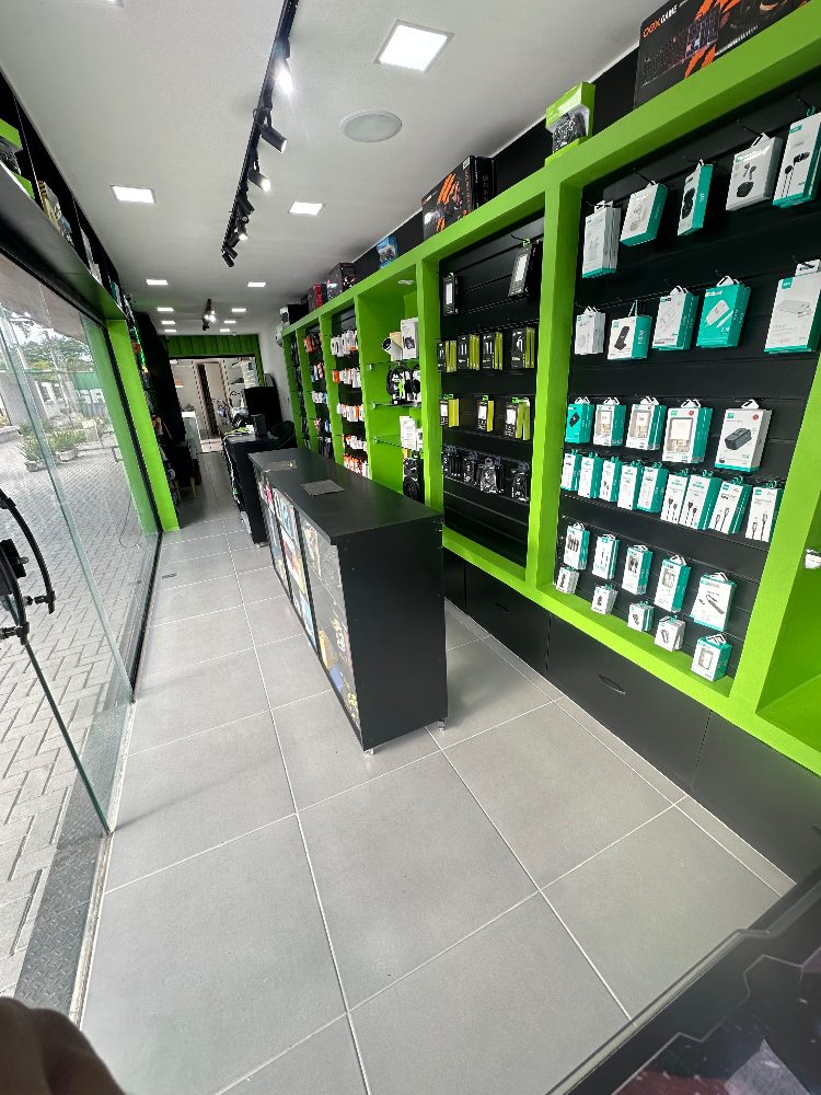 Interior da loja Pera Acessórios com parede verde de acessórios